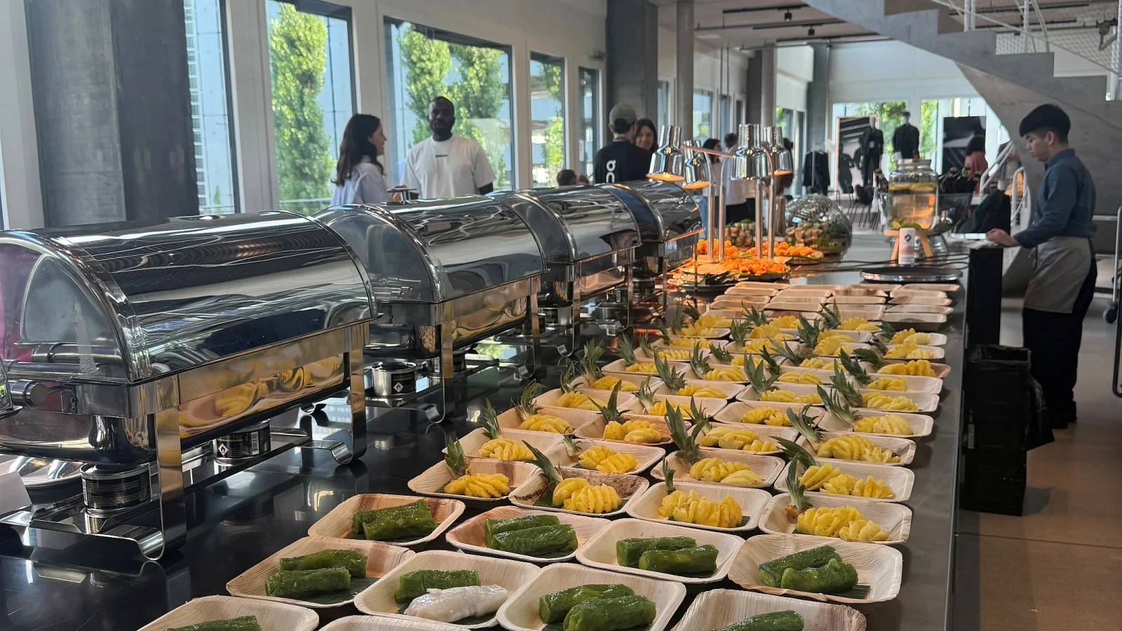Catering-Buffet mit Chafing Dishes und vietnamesischen Desserts auf Palmblatt-Schalen