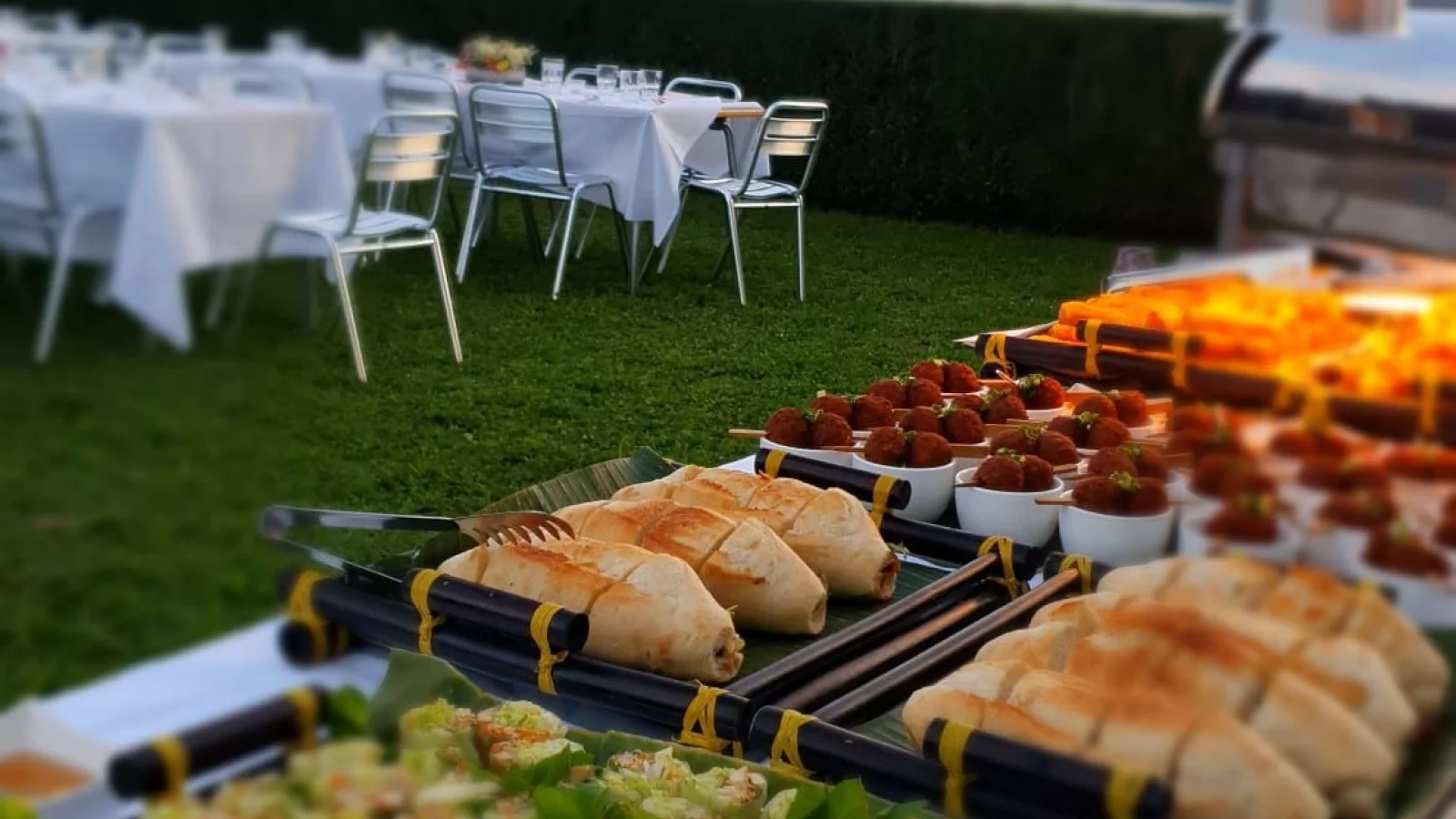 Sommerrollen und Fingerfood auf Catering-Buffet mit Seeblick bei Sonnenuntergang